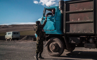 Armeński żołnierz sprawdza dokumenty kierowcy ciężarówki w punkcie kontrolnym na granicy z Azerbejdż