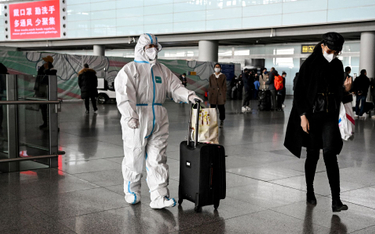Pasażer w odzieży ochronnej na lotnisku w Pekinie