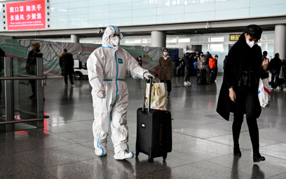 Pasażer w odzieży ochronnej na lotnisku w Pekinie