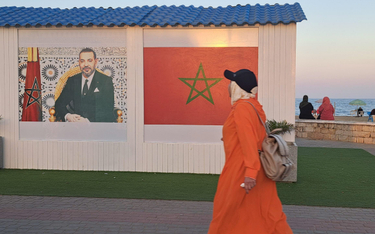 Król Maroka Mohamed VI i flaga państwa na każdym murze