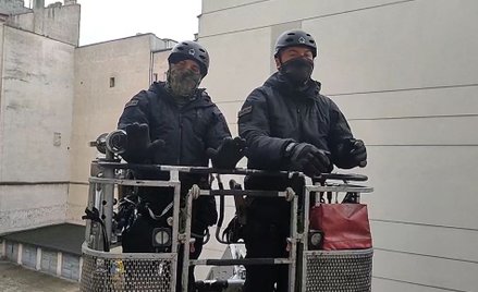 Policjanci w koszu strażackiego wysięgnika podczas rozmowy z członkami Lotnej Brygady Opozycji