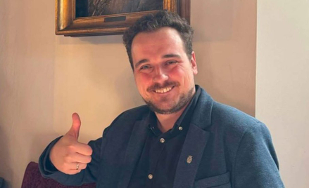 Artur Wójcik z portretem Karola Estreichera w tle