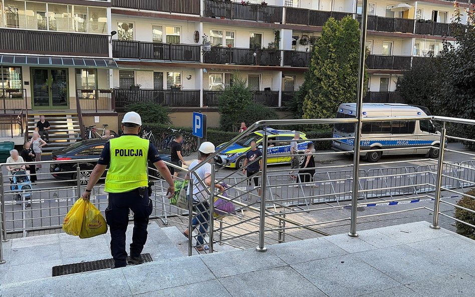 Policjanci przed spalonym budynkiem w Ząbkach