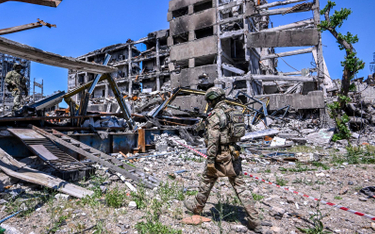 Rosyjski żołnierz obok zniszczonej przez najeźdźców huty Azowstal w Mariupolu