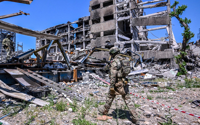 Rosyjski żołnierz obok zniszczonej przez najeźdźców huty Azowstal w Mariupolu