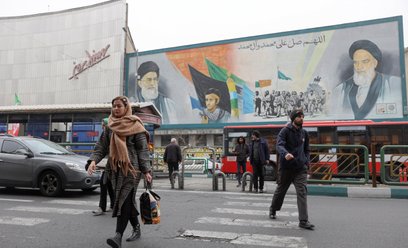 Ludzie przechodzą obok muralu z wizerunkiem Najwyższego Przywódcy Iranu, ajatollaha Alego Chameneieg