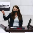 Zuleyha Gulum z Ludowej Partii Demokratycznej trzyma transparent „Prawdy nie da się ukryć”, stojąc z