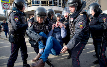 Policja niesie jednego z aresztowanych na placu Puszkina w Moskwie