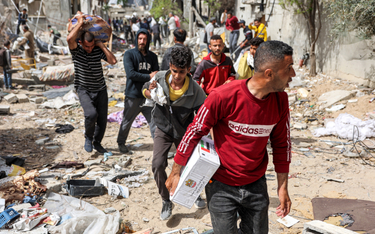Palestyńczycy z paczkami pomocy humanitarnej zebranymi ze zrzutu nad północną Strefą Gazy