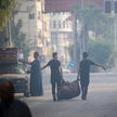 Palestyńczycy opuszczają domostwa w pobliżu wieży Al-Watan w mieście Gaza, po jej zniszczeniu w wyni