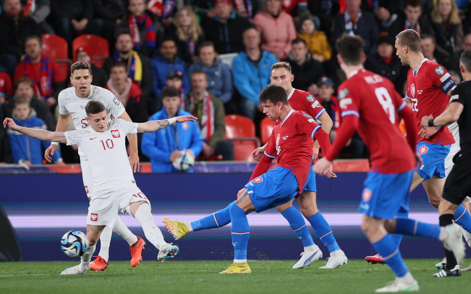 Mecz w Pradze. Sebastian Szymański stara się zablokować strzał Adama Hlozka. W głębi Jan Bednarek