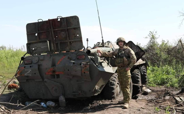 Ukraiński żołnierz z porzuconym przez Rosjan transporterem