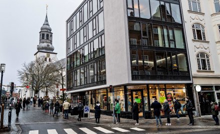 Ludzie ustawiają się w kolejce do szybkiego testowania w centrum Aalborga zorganizowanym przy koście