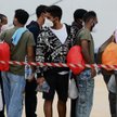 Migranci w kolejce przed wejściem na pokład łodzi w porcie na wyspie Lampedusa.