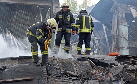 Ukraińscy strażacy w ruinach budynku, w który uderzył rosyjski pocisk manewrujący (fot. ilustracyjna