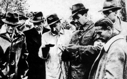 21 lub 22 maja 1943 roku. Józef Mackiewicz (w środku) w Lesie Katyńskim przegląda dokumenty zamordow