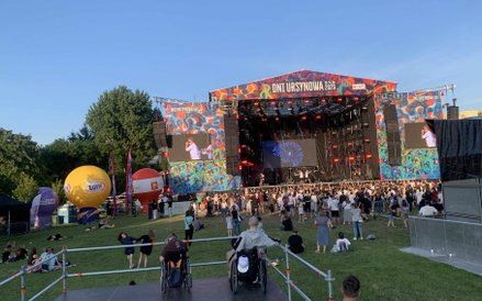 Widok na scenę główną z sektora dla osób z niepełnosprawnościami. Uczestnicy w wózkach inwalidzkich 