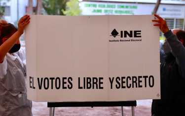 Członkowie jednej z komisji wyborczych w Meksyku ustawiają parawan z hasłem "Głosowanie jest wolne i