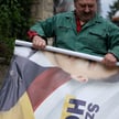 Mężczyzna usuwa plakat wyborczy przewodniczącego Sejmu RP Szymona Hołowni, Opatów, 19 maja