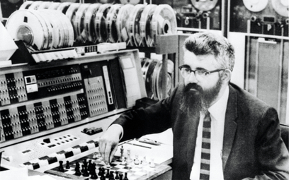 Prof. John McCarthy ustawia szachownicę obok komputera IBM 7090 w ramach przygotowań do międzynarodo