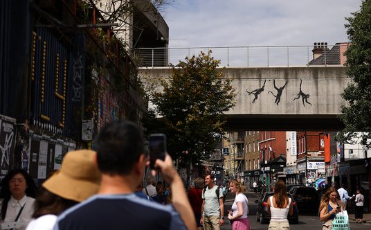 Trzeci z cyklu 9 murali Banksy'ego: małpy wiszące na wiadukcie kolejowym we wschodnim Londynie.