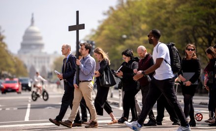 Amerykańscy katolicy niosą na zmianę drewniany krzyż podczas procesji Drogi Krzyżowej niedaleko kopu