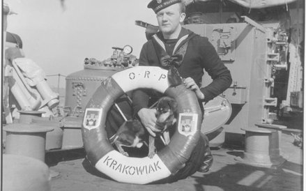 Harwich 1946 roku. Pamiątkowe zdjęcie marynarza z ORP „Krakowiak” z kołem ratunkowym i psem Ciapkiem