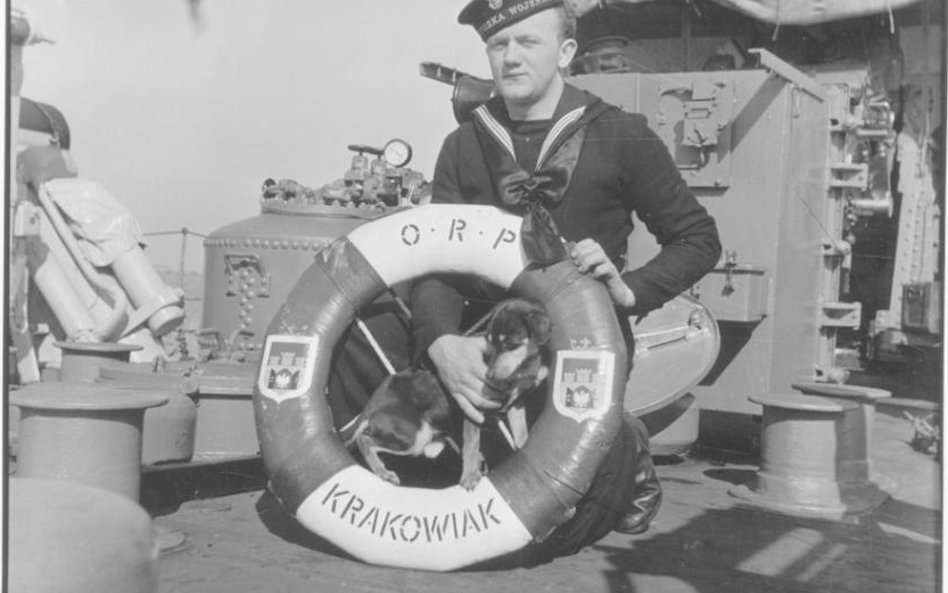 Harwich 1946 roku. Pamiątkowe zdjęcie marynarza z ORP „Krakowiak” z kołem ratunkowym i psem Ciapkiem