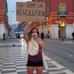 Kobieta trzyma hasło „Pachnie rewolucją” podczas demonstracji przeciwko „wysokim kosztom życia” na P