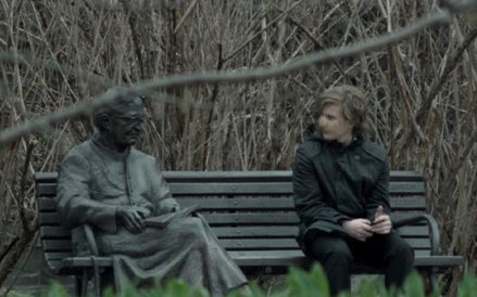 Młody karateka na ławeczce z ks. Janem Twardowskim