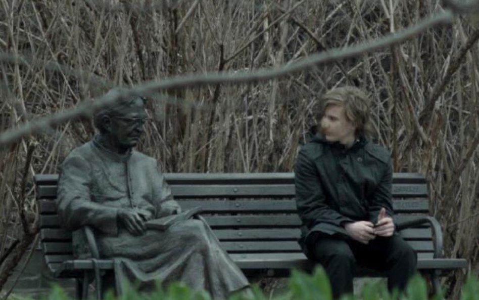 Młody karateka na ławeczce z ks. Janem Twardowskim