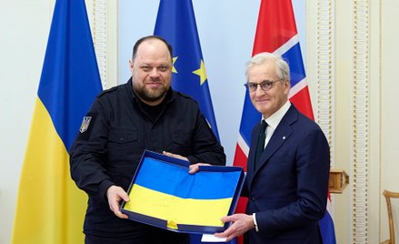 Przewodniczący Rady Najwyższej (parlamentu Ukrainy) Rusłan Stefanczuk (L) przekazuje ukraińską flagę