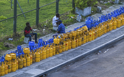 Ludzie ustawiają się z setkami butli na płynny gaz w kolejkach, aby wymienić je na pełne.