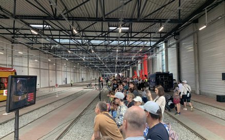 Widzowie zgromadzeni wzdłuż torów, obserwują przebieg konkurencji na żywo i na ekranie