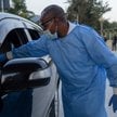 Pracownik służby zdrowia z Konga mierzy temperaturę podróżnemu na granicy z Rwandą