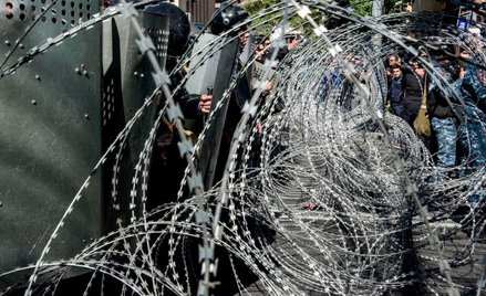 Rozciągnięty przed budynkiem parlamentu drut kolczasty symbolizuje kryzys polityczny w Armenii.