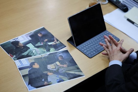 Przedstawiciel opozycji z Korei Południowej omawia zdjęcia przedstawiające dwóch północnokoreańskich