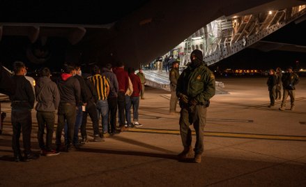 Agenci Służby Celnej i Ochrony Granic USA nadzorują lokowanie zatrzymanych migrantów na pokład samol