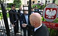 Sędzia TK Marcin Dziurda (C) wita się przez furtkę z sędzią Bartłomiejem Starostą, członkiem nowej K