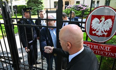 Sędzia TK Marcin Dziurda (C) wita się przez furtkę z sędzią Bartłomiejem Starostą, członkiem nowej K