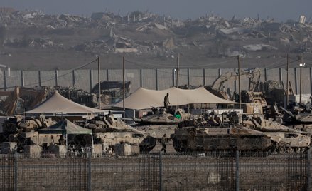 Żołnierze Sił Obronnych Izraela gromadzą się w pobliżu pojazdów wojskowych i ciężkiego sprzętu wzdłu