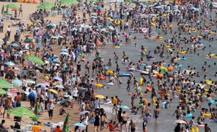 Chińczycy w upalne letnie dni spędzają wolny czas na plaży w miejscowości Qingdao w chińskiej prowin