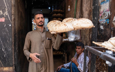 Sprzedawca chleba na targu spożywczym Al-Mgharblin w dzielnicy al-Darb al-Ahmar w Kairze w Egipcie