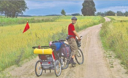 Piotr Piłaciński z synkiem Maćkiem (w przyczepce) na rowerowych wakacjach na Suwalszczyźnie