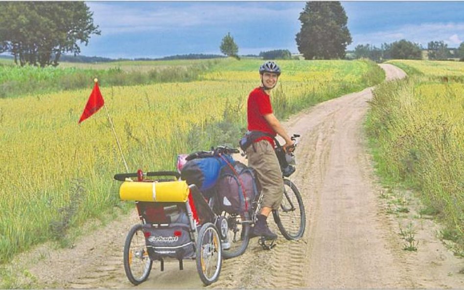 Piotr Piłaciński z synkiem Maćkiem (w przyczepce) na rowerowych wakacjach na Suwalszczyźnie