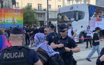 Odizolowana ciężarówka Maersk z protestującymi na kontenerze. Wokół pojazdu widać policjantów zabezp