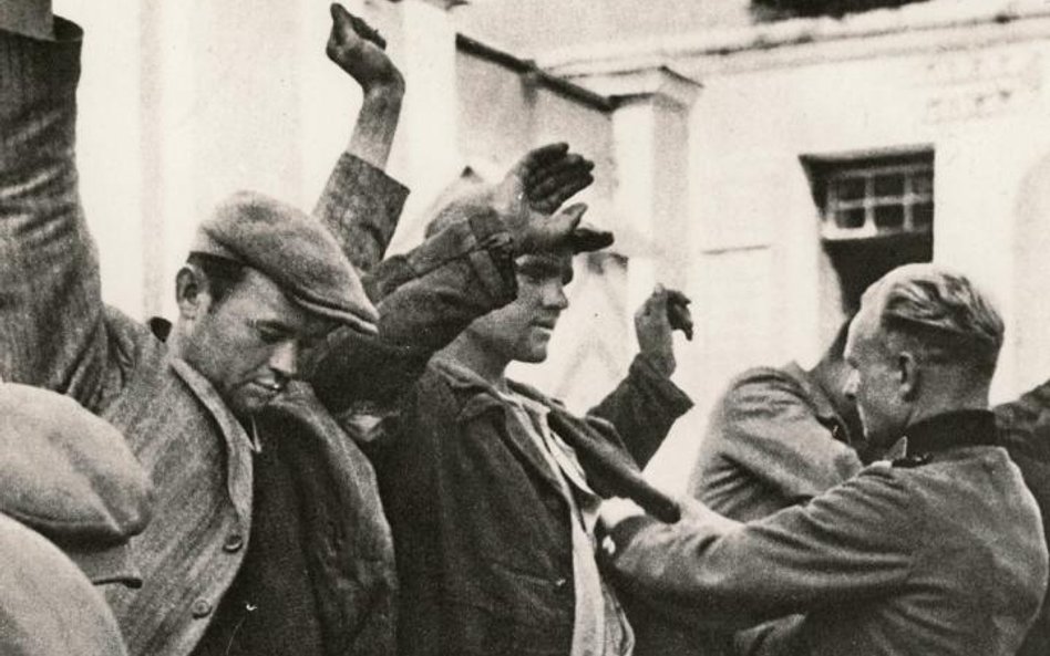 Październik 1939. Żołnierze niemieccy przeszukują zatrzymanych Polaków.