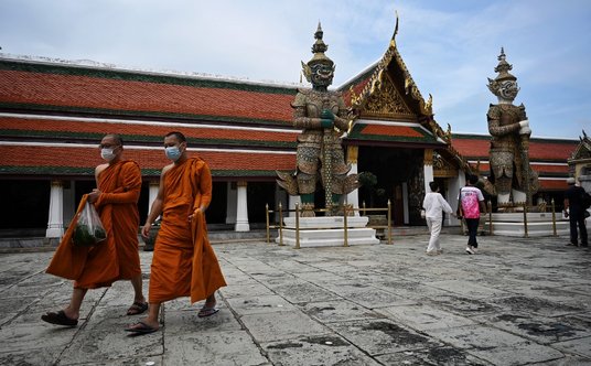 Mnisi buddyjscy spieszący do świątyni to zwykły widok na ulicach Tajlandii