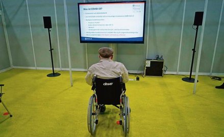 92-letni Herri Rehfeld czyta instrukcję przed poddaniem się szczepieniu w Berlinie