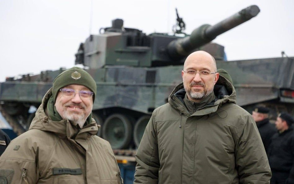 Szef MON Ołeksij Reznikow i premier Denys Szmyhal. W tle pierwsze dostarczone przez Polskę leopardy